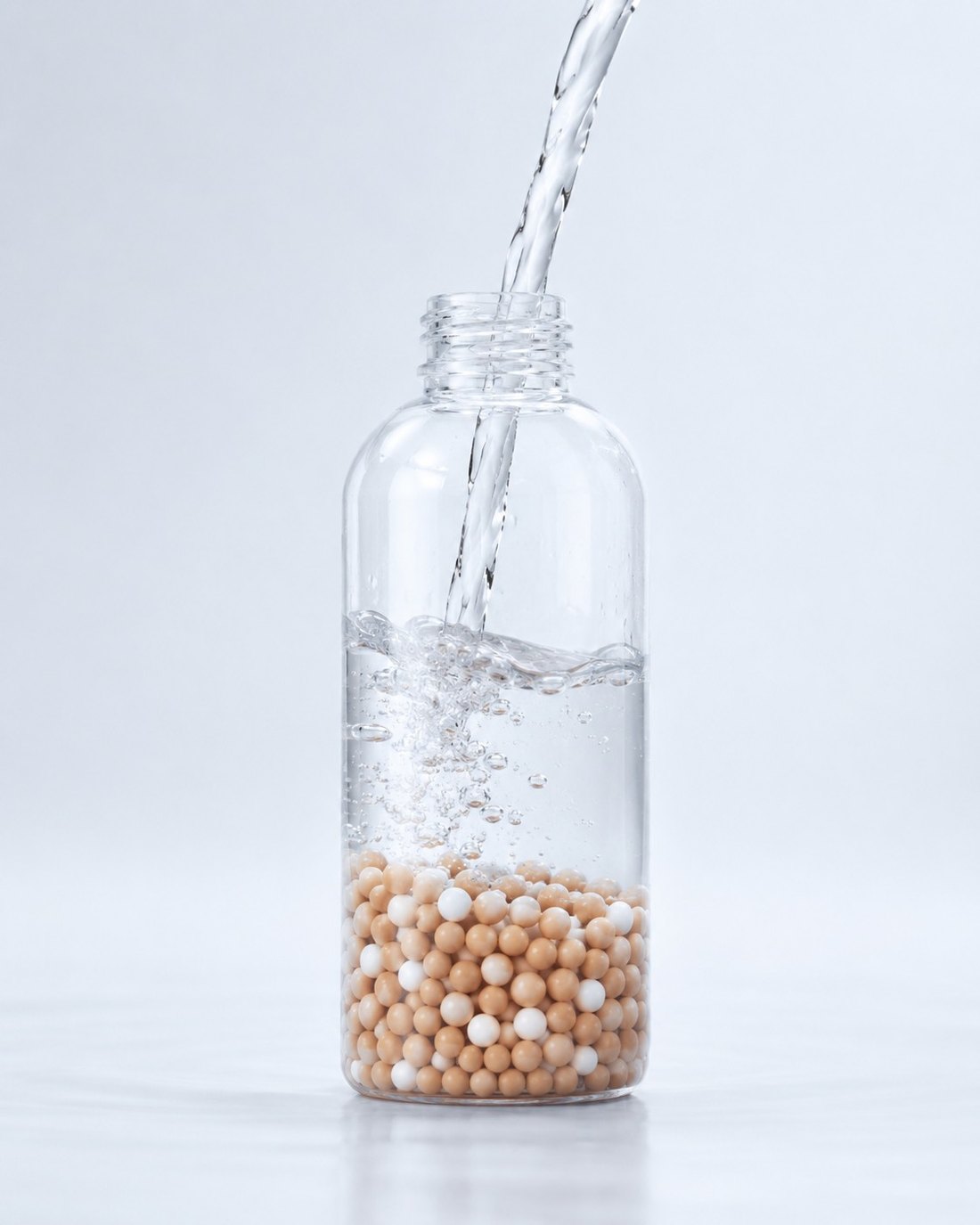 Pouring water into a bottle filled with NATURU Plus silver-zeolite beads